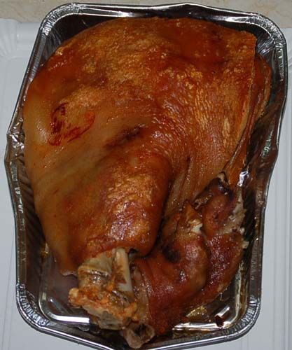 Un trozo grande de carne está en un recipiente de papel de aluminio.