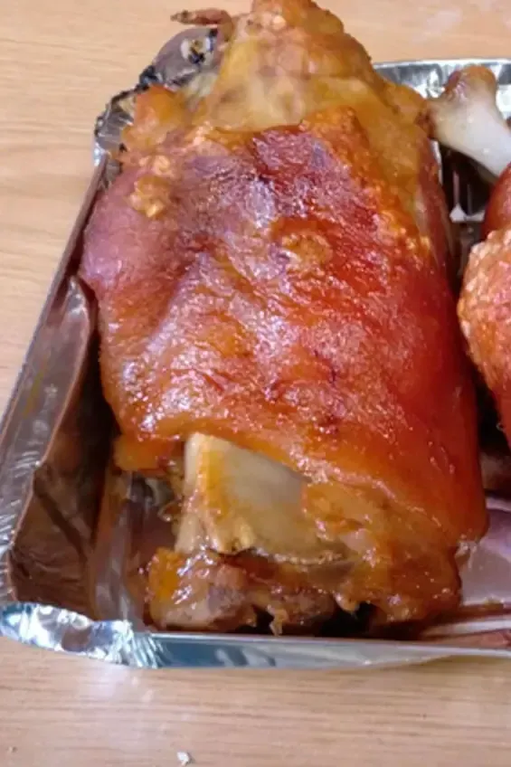 Un primer plano de un trozo de carne en una bandeja de aluminio sobre una mesa.
