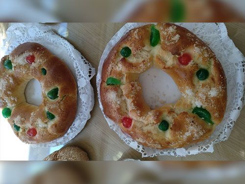 Hay dos panes sobre un plato blanco sobre una mesa.