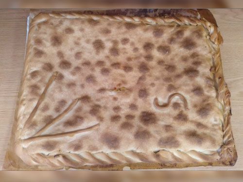 Un pastel grande está sobre una mesa de madera.