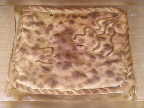 Un trozo de pan está sobre una mesa de madera.