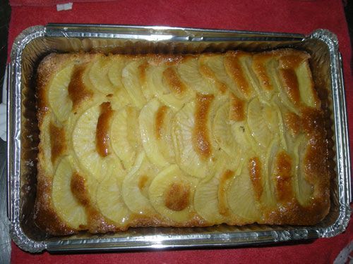 Una cazuela llena de rodajas de manzana sobre un paño rojo.