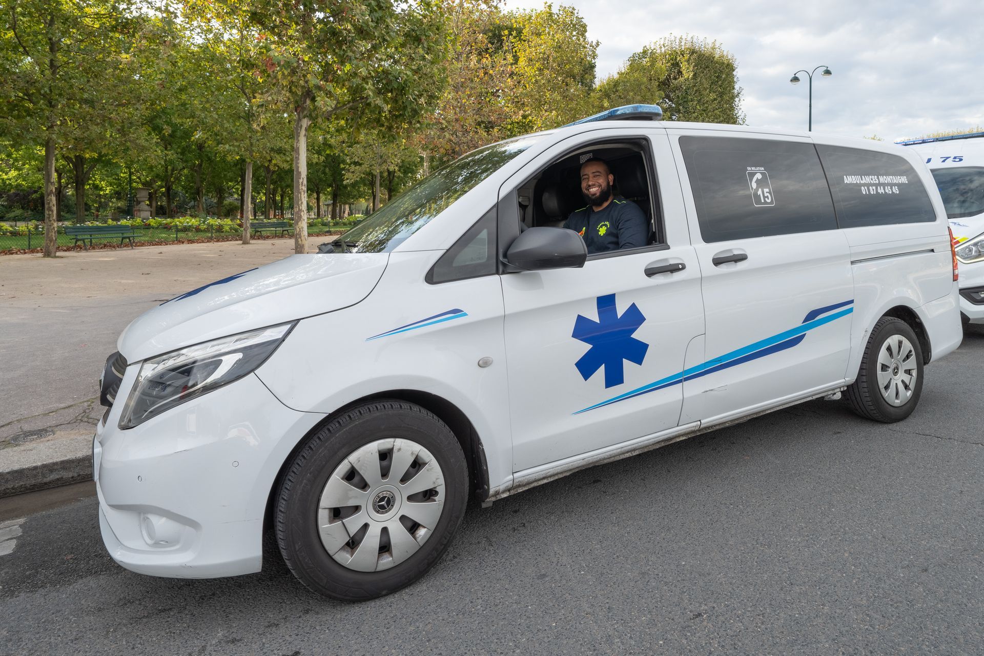 Ambulancier souriant au volant de son véhicule