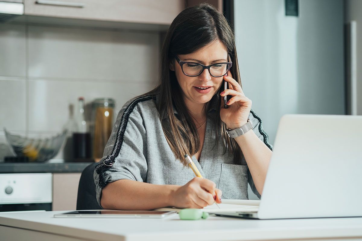 Femme au téléphone devant son ordinateur