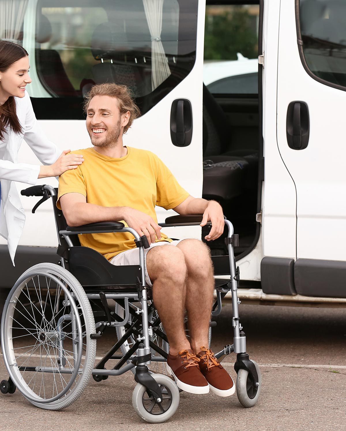 Infirmière qui pousse un jeune en fauteuil roulant