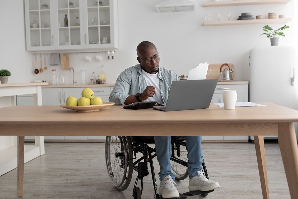 Homme en fauteuil roulant qui vérifie ses factures