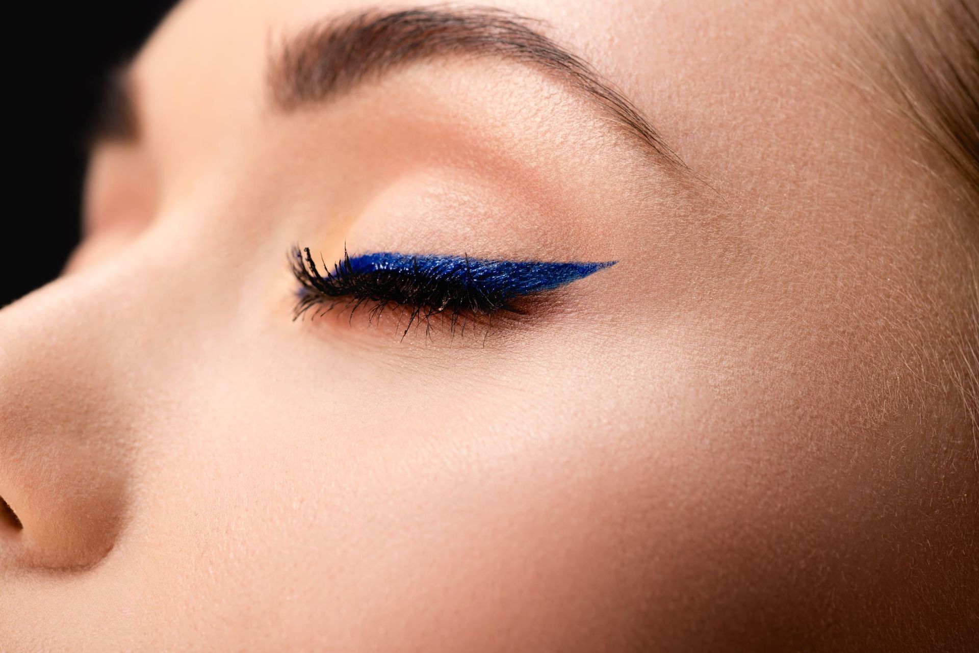 Un primer plano del ojo de una mujer con delineador azul.
