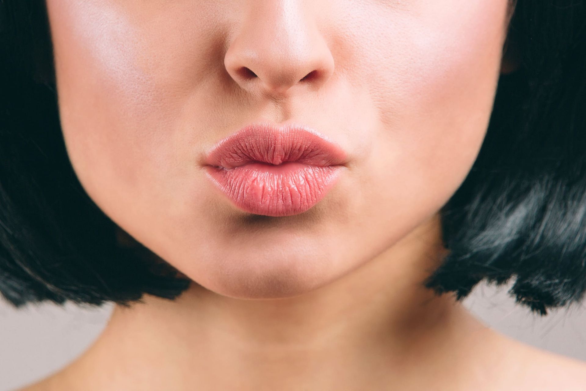 Un primer plano de los labios de una mujer con lápiz labial rojo.