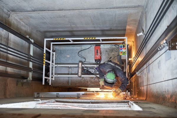 Un hombre está trabajando en un ascensor en un edificio.