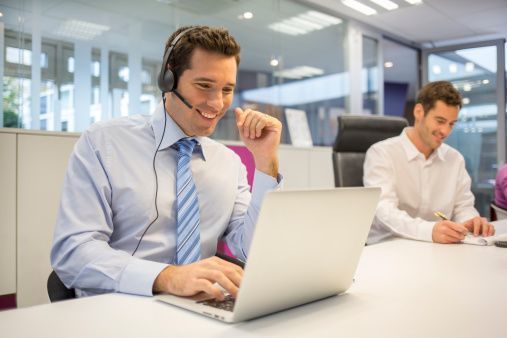 Un hombre que lleva unos auriculares está usando una computadora portátil.