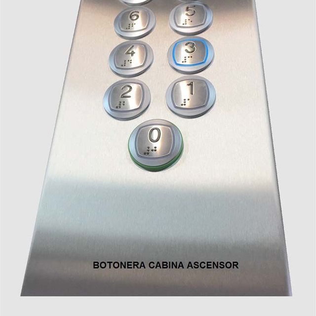 Un panel de control de ascensor de acero inoxidable que dice botonera cabina ascensor