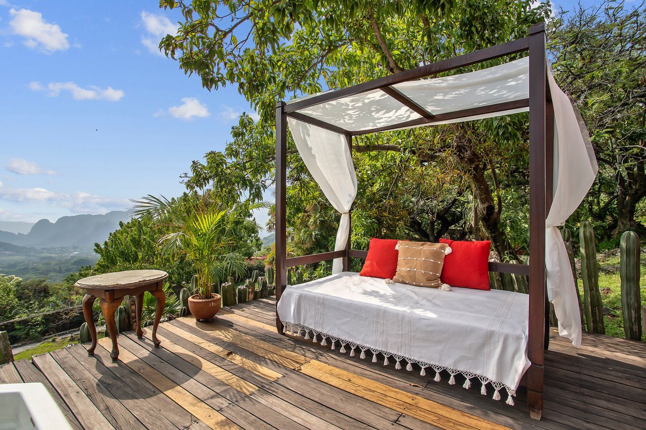 A canopy bed is sitting on top of a wooden deck.