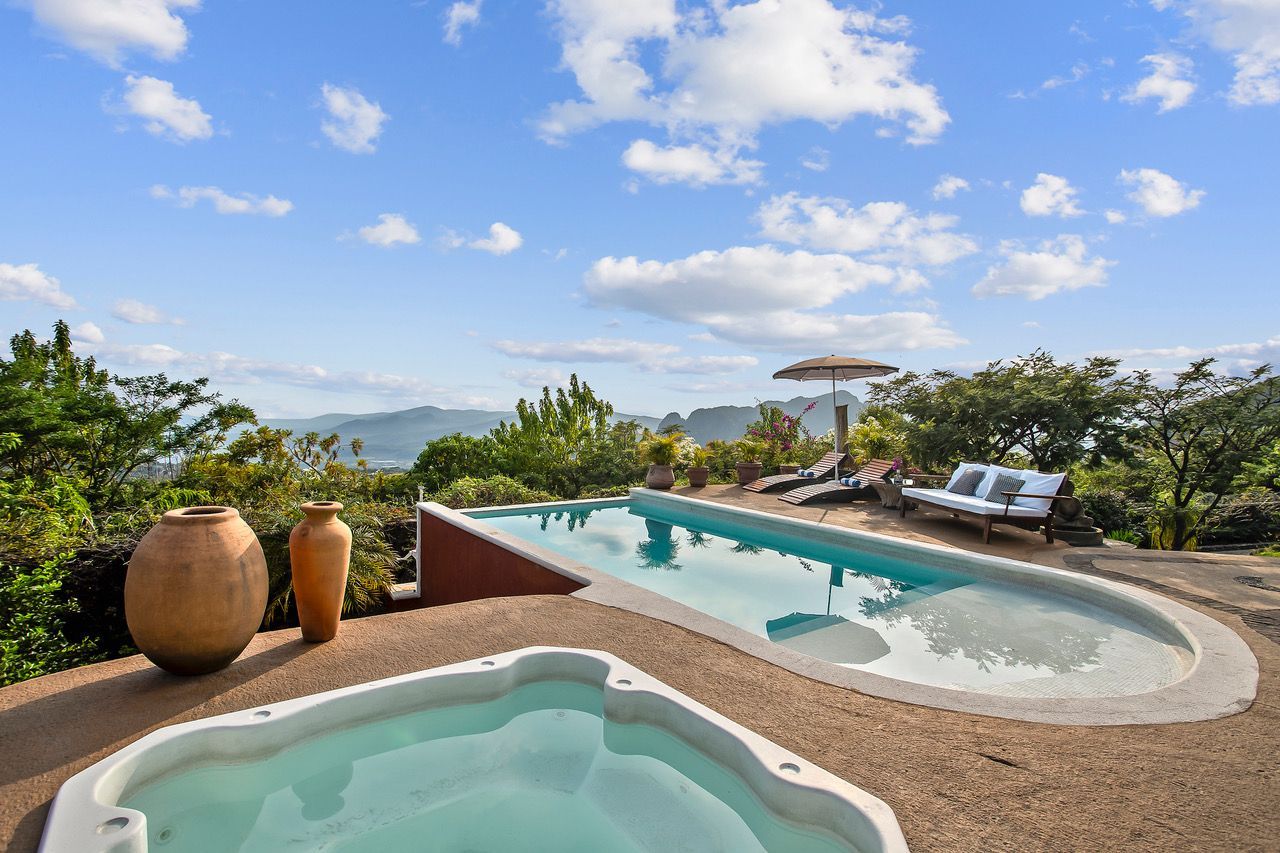 A large swimming pool with a hot tub next to it.