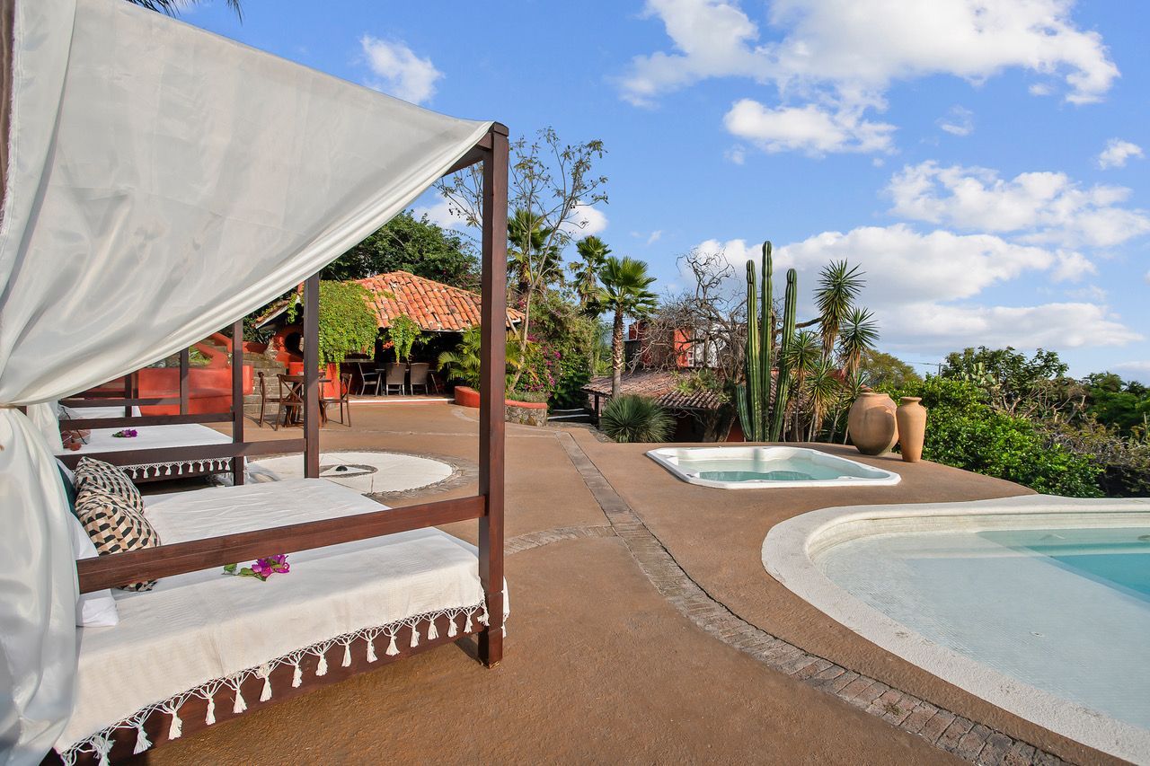 A canopy bed is sitting next to a swimming pool.