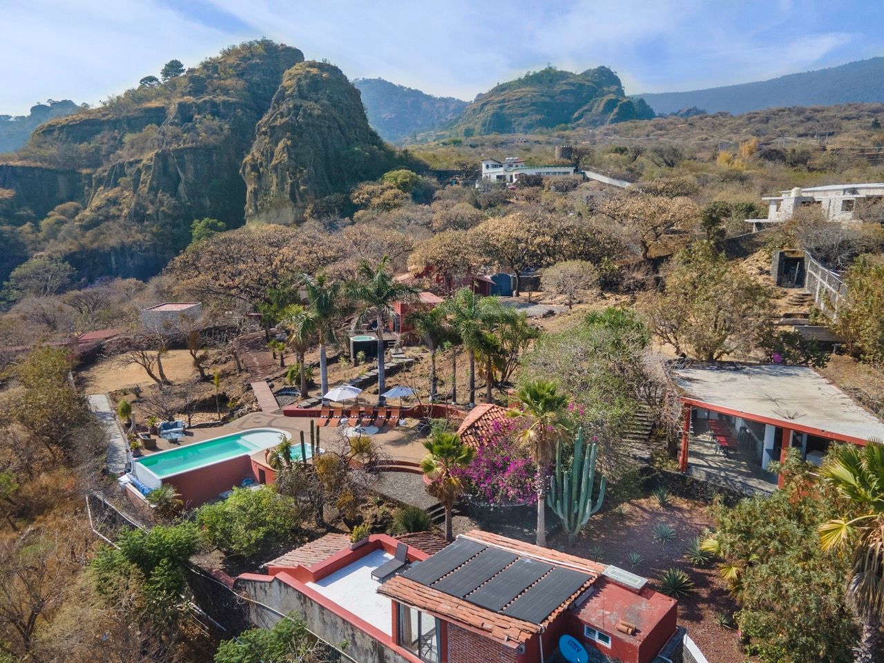 An aerial view of a house with a pool and mountains in the background