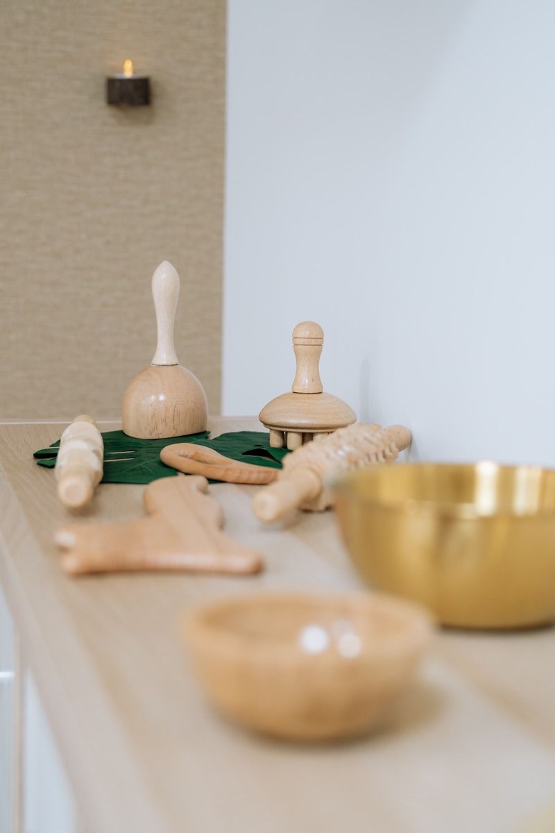 Una mesa con objetos de madera y un cuenco sobre ella.