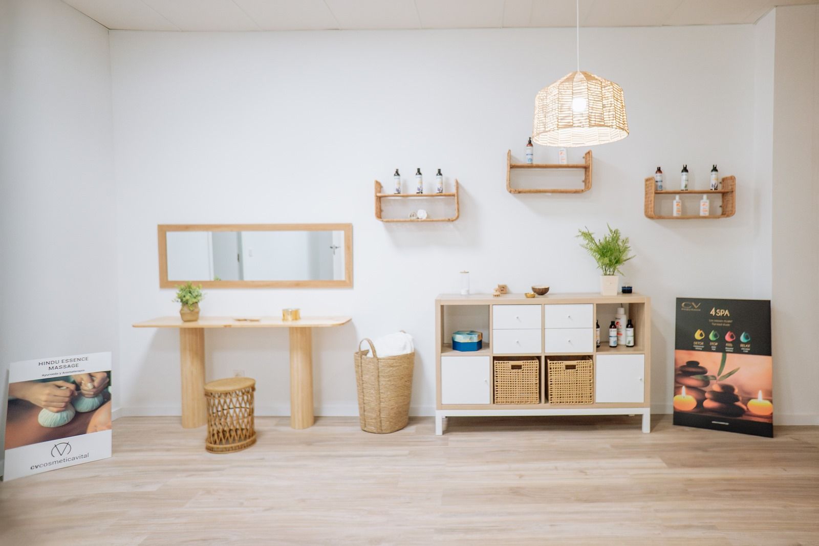 Una habitación con suelo de madera, una mesa, un espejo y un estante.