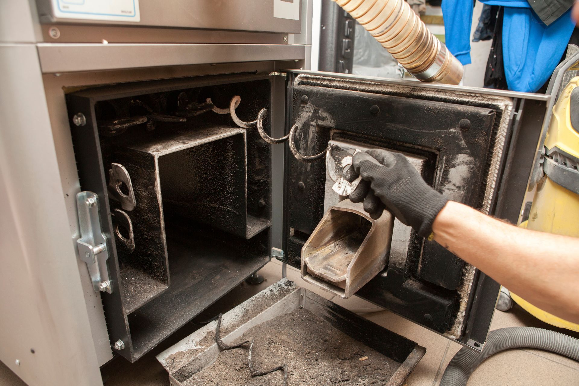 Un technicien pendant l'entretien d'une chaudière à bois