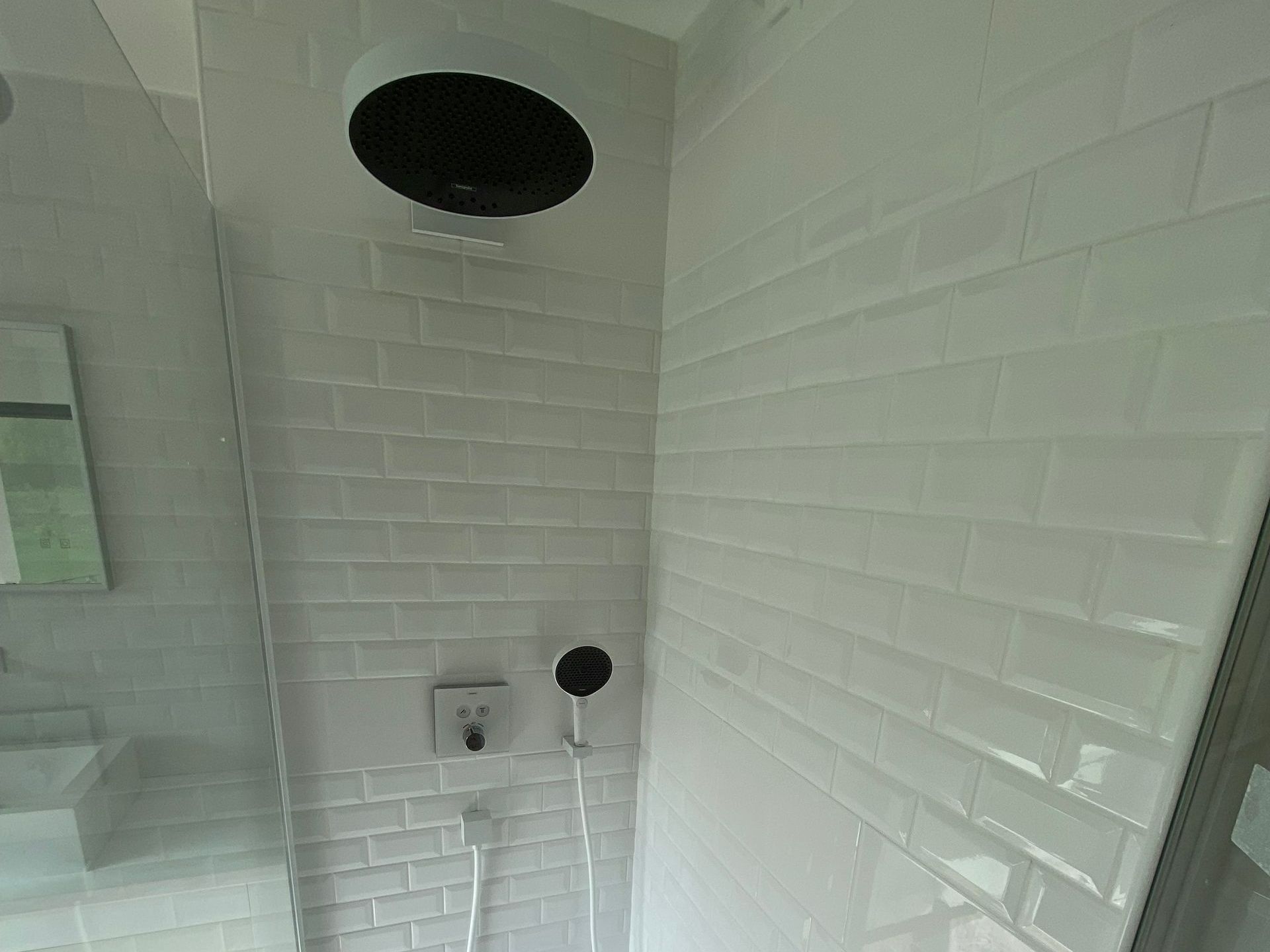 Une douche rénovée avec une faïence blanche