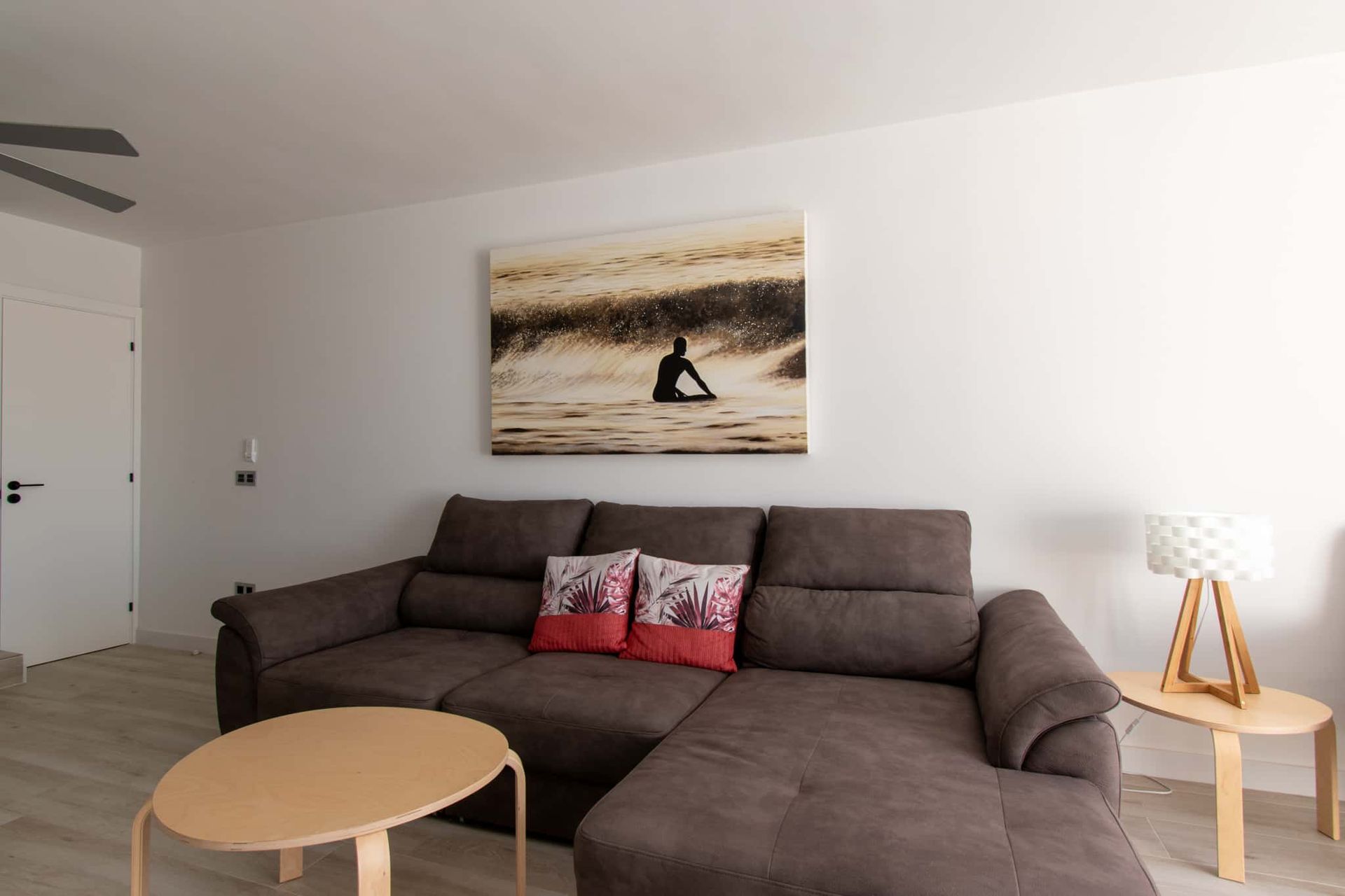 A living room with a black couch and yellow pillows