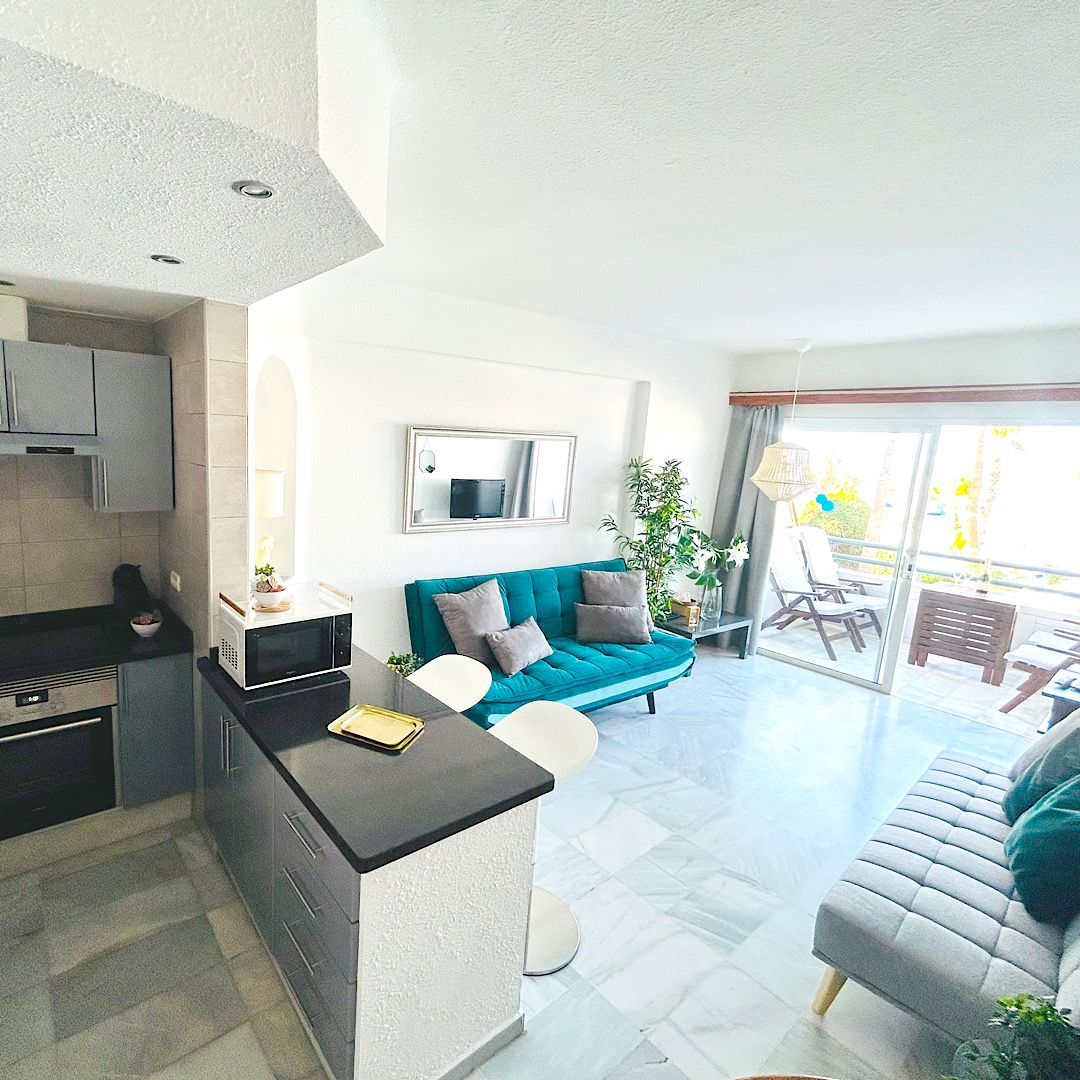 A living room with a black couch and yellow pillows