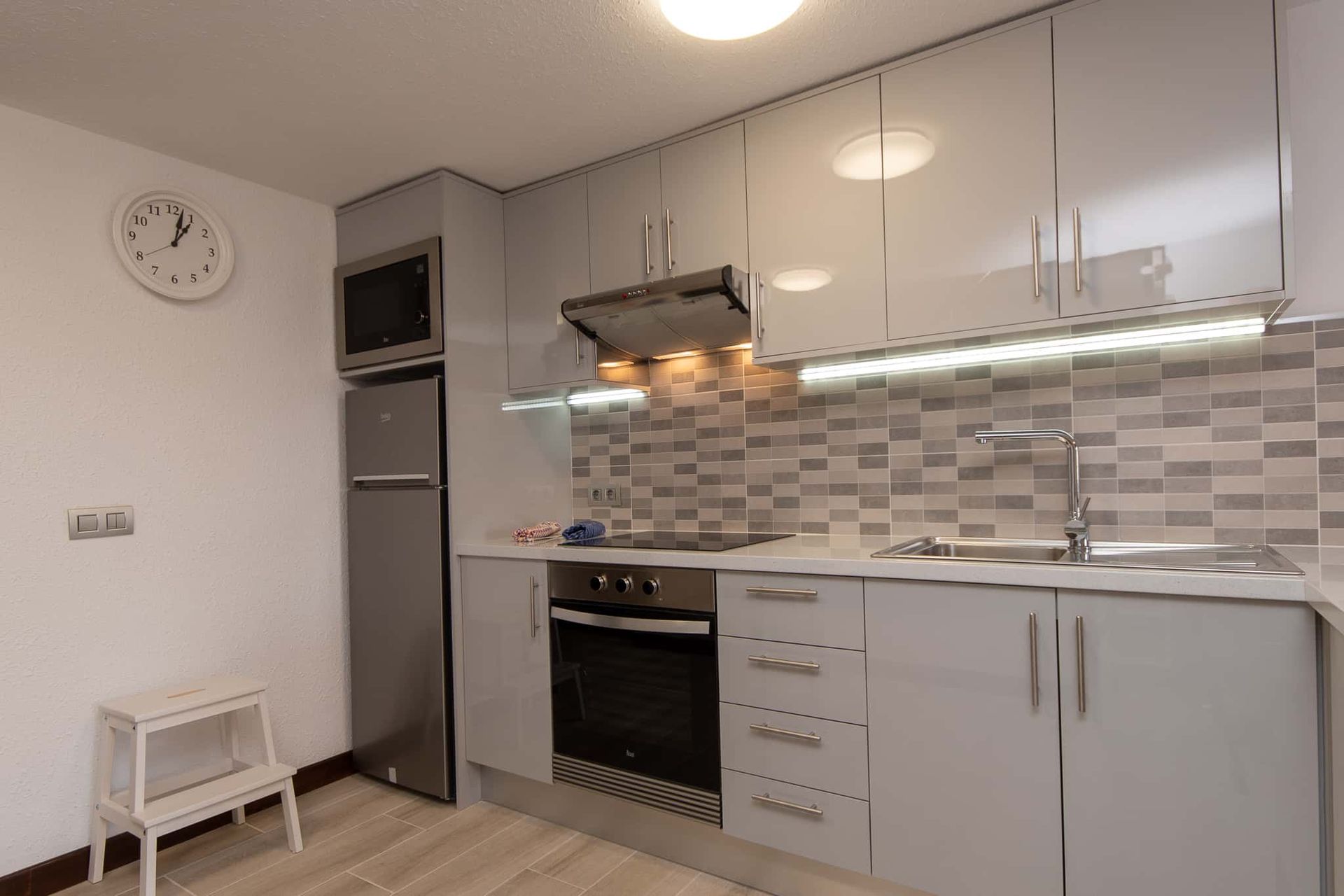 Kitchen with oven, hob, extractor fan, tall fridge freezer, microwave, clock at Parque Santiago II, Playa de las Americas, Tenerife