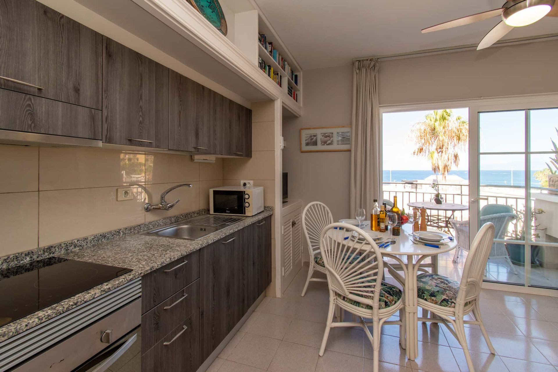 Kitchen with oven, hob, microwave, sink, dining table and chairs, Los Olivos, Costa Adeje, Tenerife.