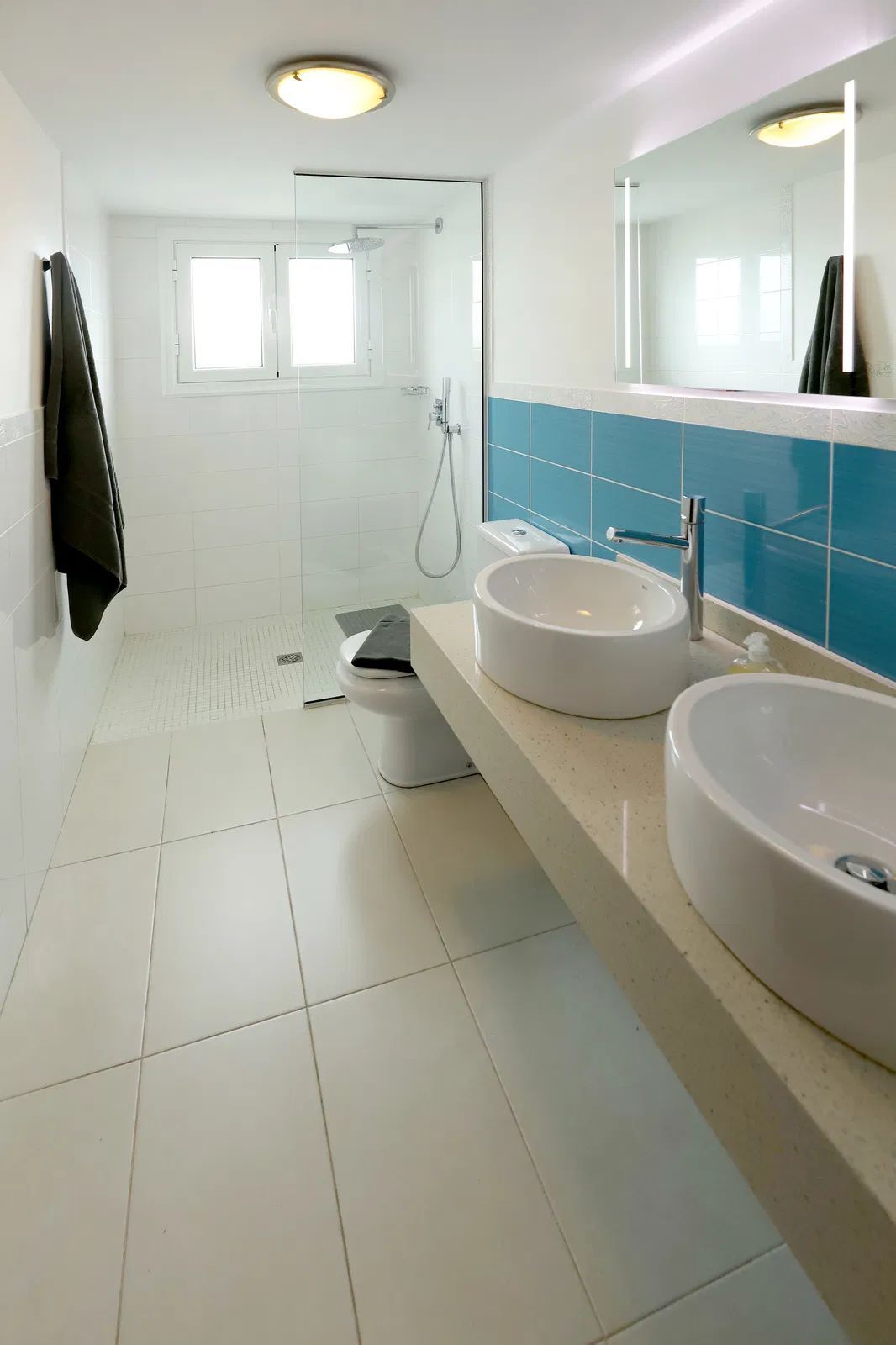 White and blue modern bathroom with two sinks and a toilet. Villa Salvo | Los Mojones | Puerto del Carmen | Lanzarote.