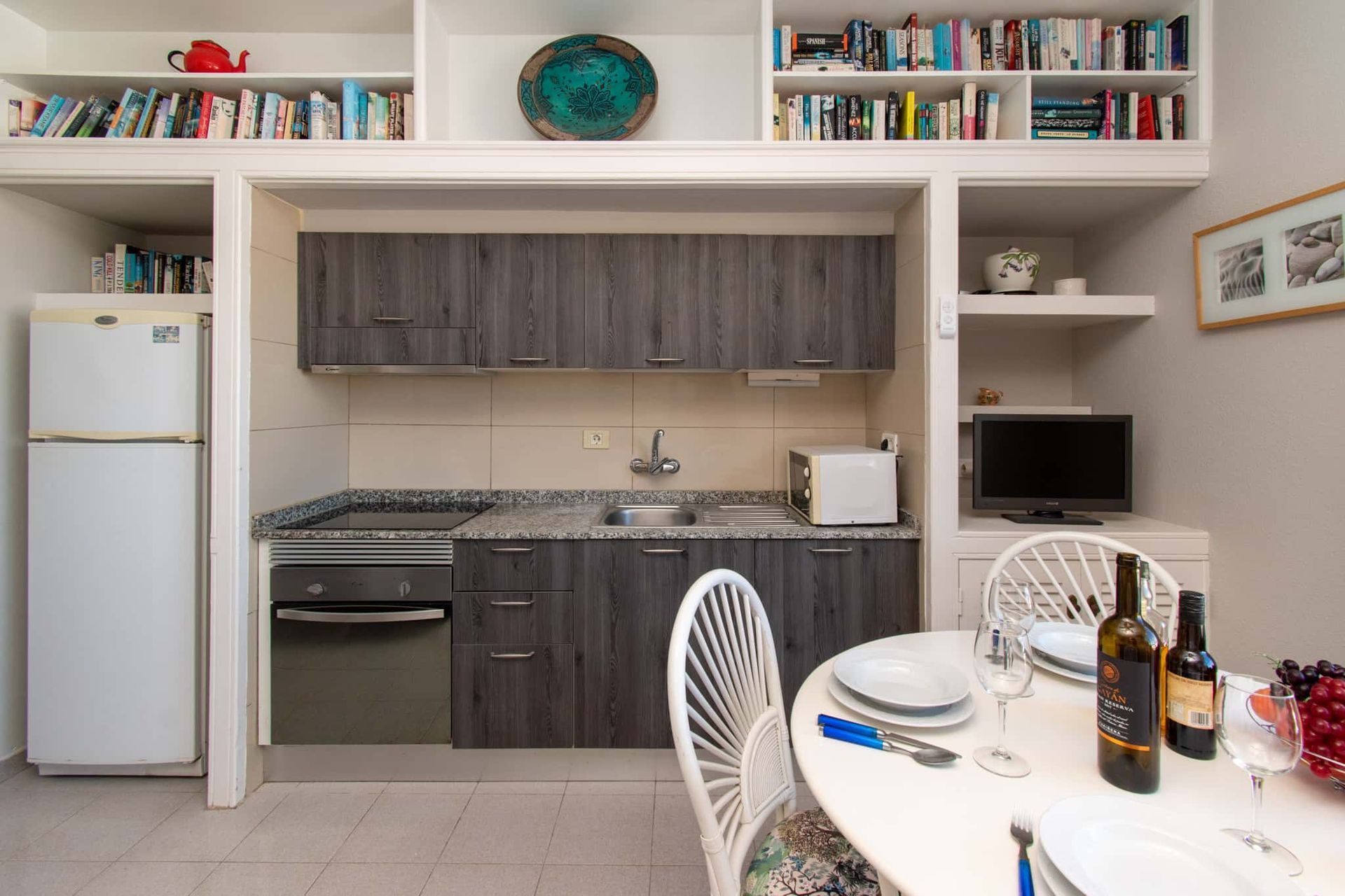 Kitchen with tall fridge/freezer, oven, hob, sink, microwave, dining table and chairs and flat screen TV, Los Olivos, Costa Adeje, Tenerife.