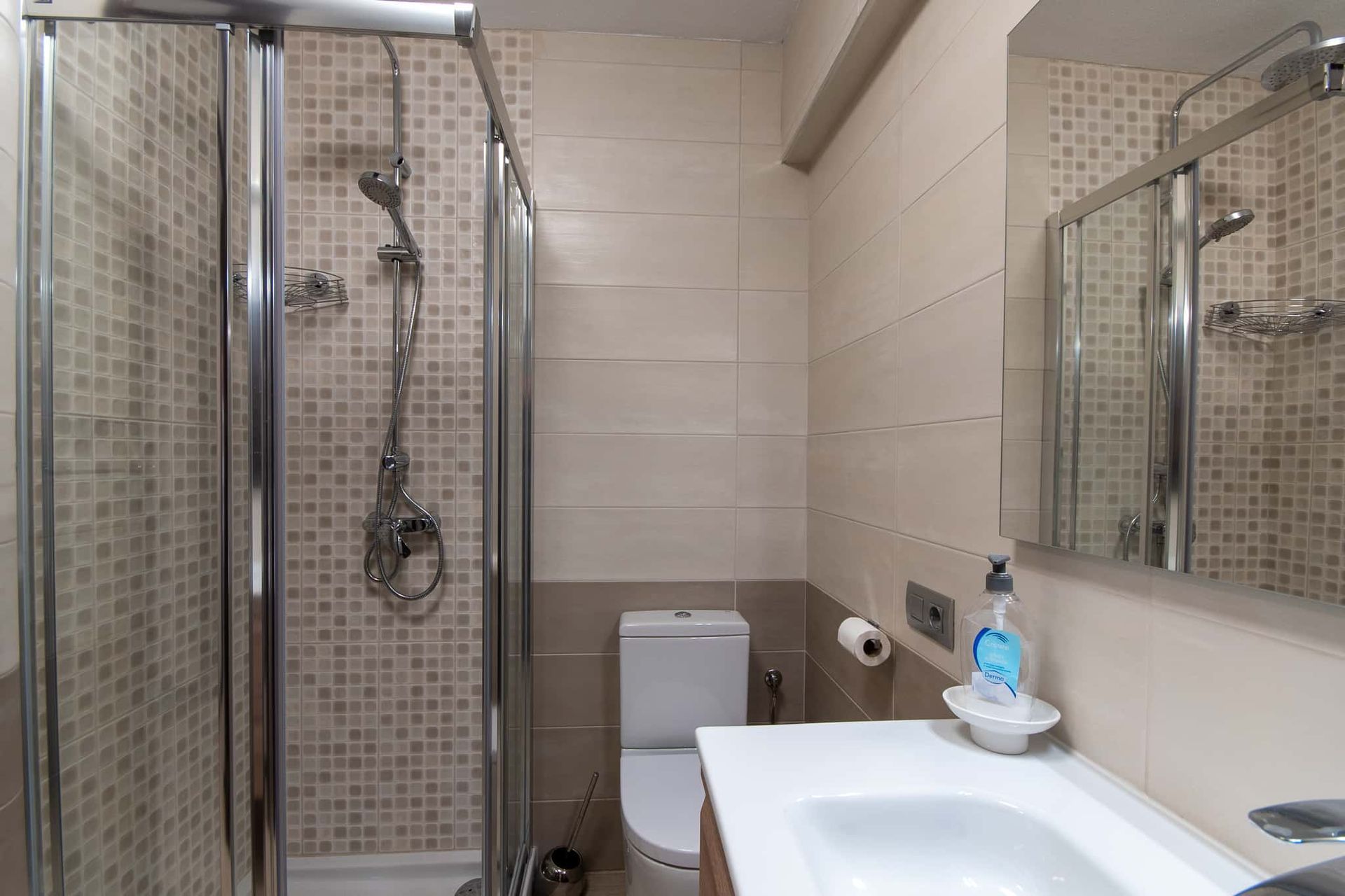 Bathroom with shower, WC, wash hand basin with mirror above at Parque Santiago II, Playa de las Americas, Tenerife