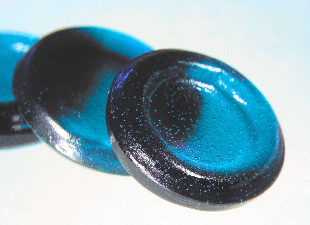 Ein Paar grüne und schwarze Knöpfe auf einer weißen Oberfläche