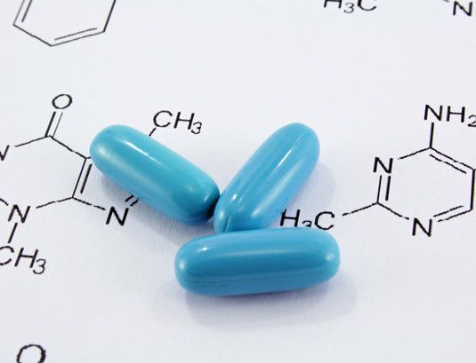 Blaue Pillen liegen auf einer chemischen Formel