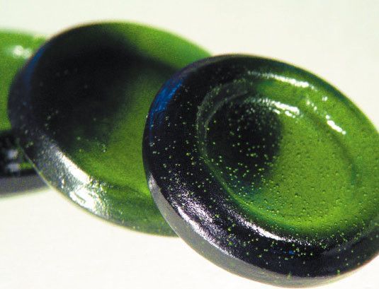 Ein Paar grüne und schwarze Knöpfe auf einer weißen Oberfläche