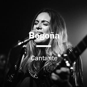 Una mujer canta en un micrófono mientras sostiene una guitarra.