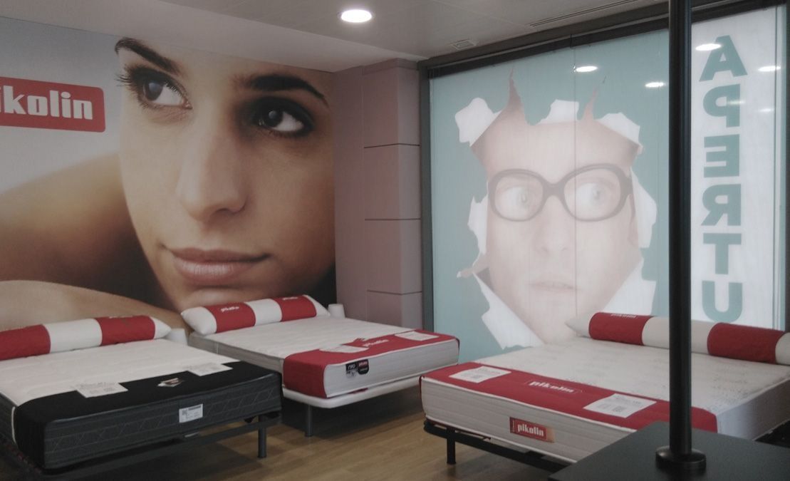 Una habitación con colchones y un cartel que dice kolin