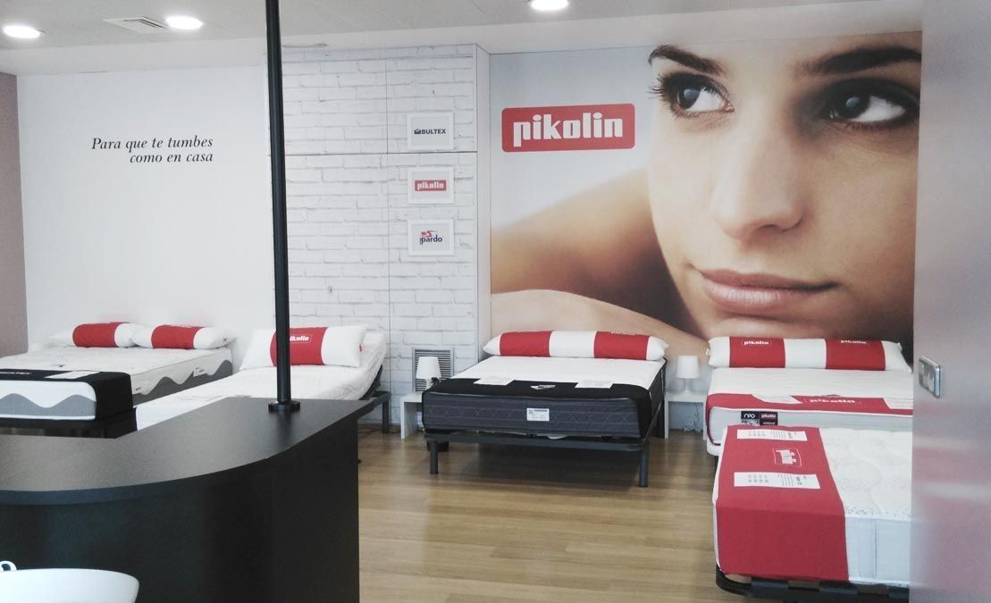 Una tienda de colchones con la cara de una mujer en la pared.