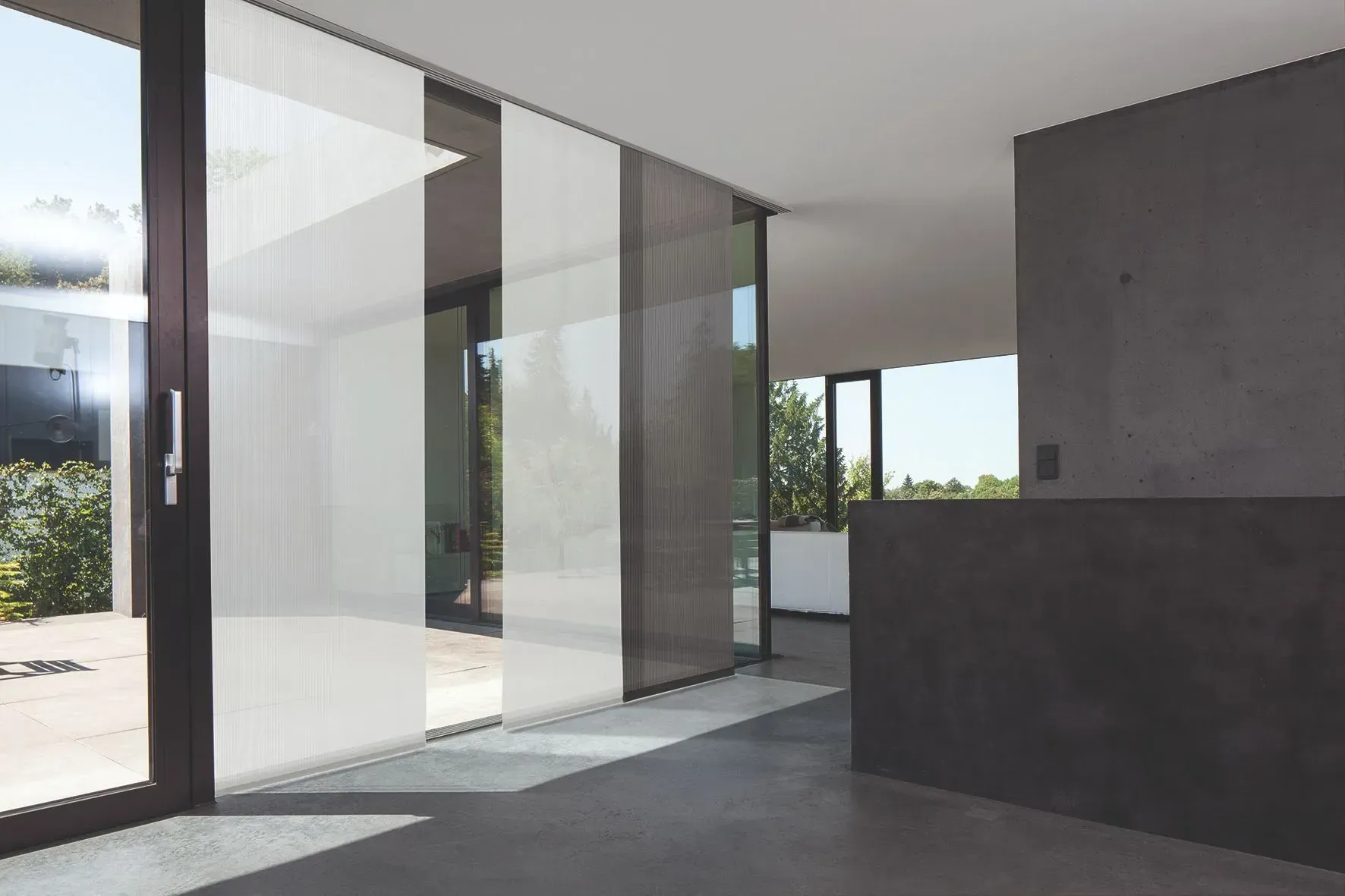 Ein Raum mit vielen Fenstern und Glasschiebetüren