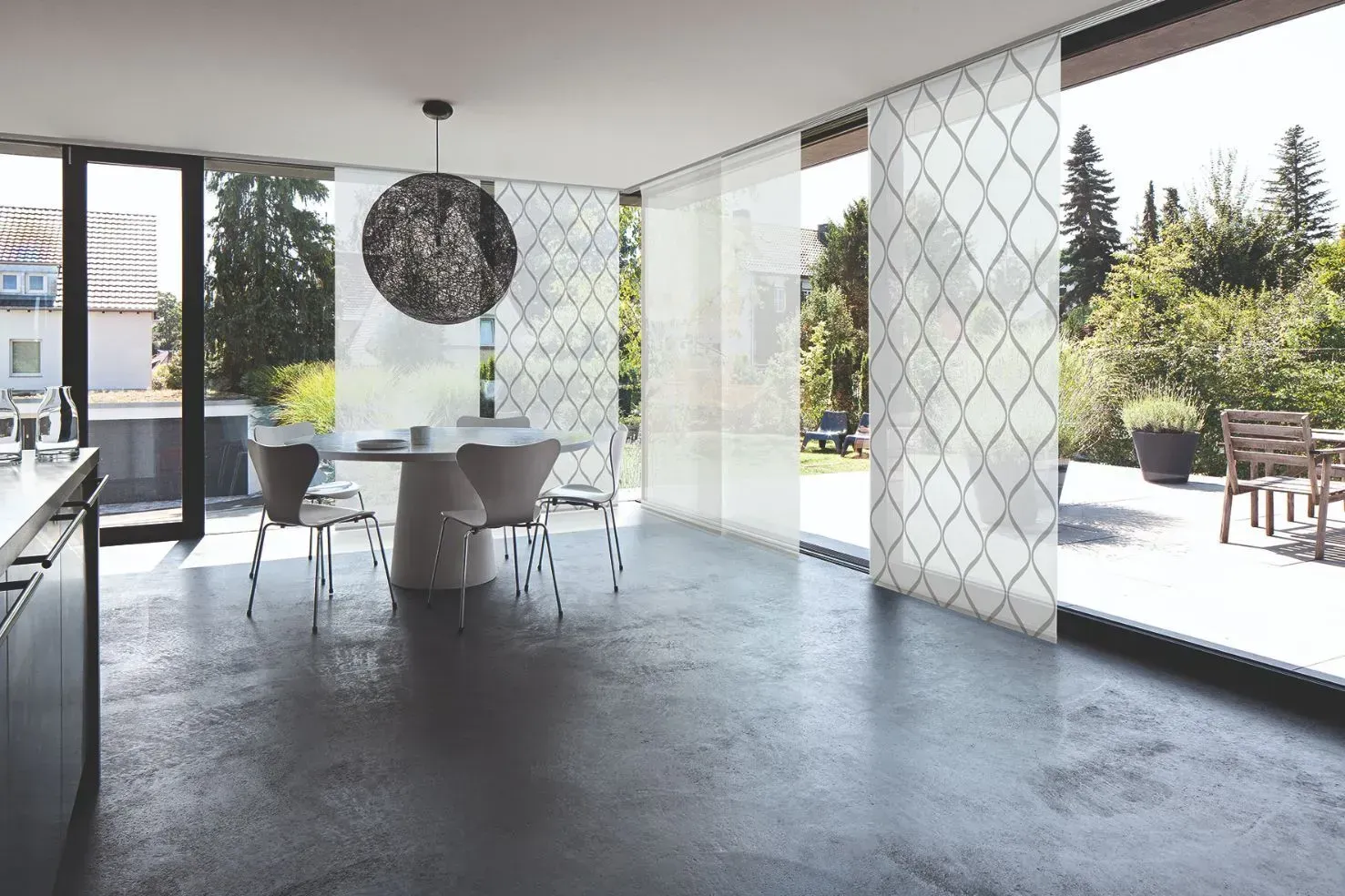 Ein Esszimmer mit Tisch und Stühlen und einem großen Fenster