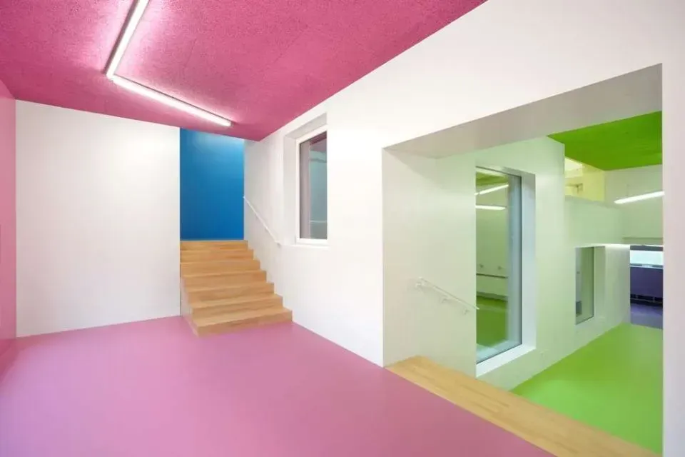 Ein Raum mit rosa Boden, weißen Wänden und pinker Decke