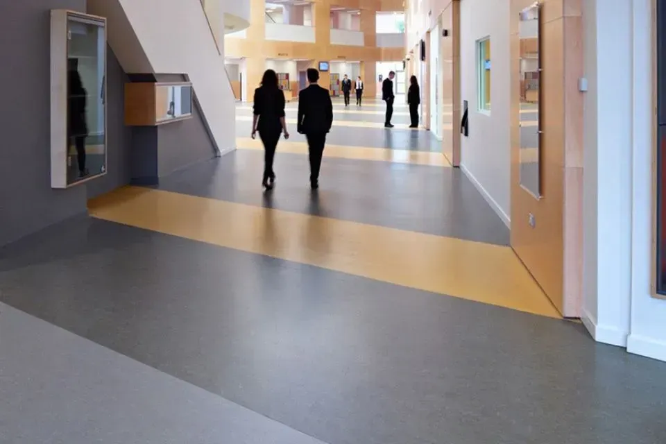 Zwei Personen gehen einen Flur in einem Gebäude entlang