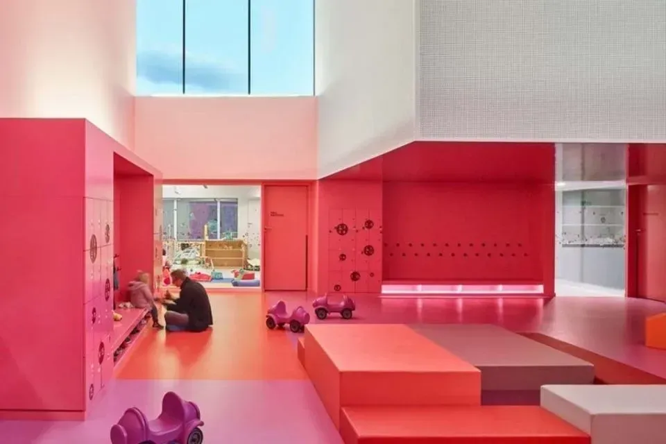 Ein Mann sitzt auf dem Boden in einem rosa Zimmer