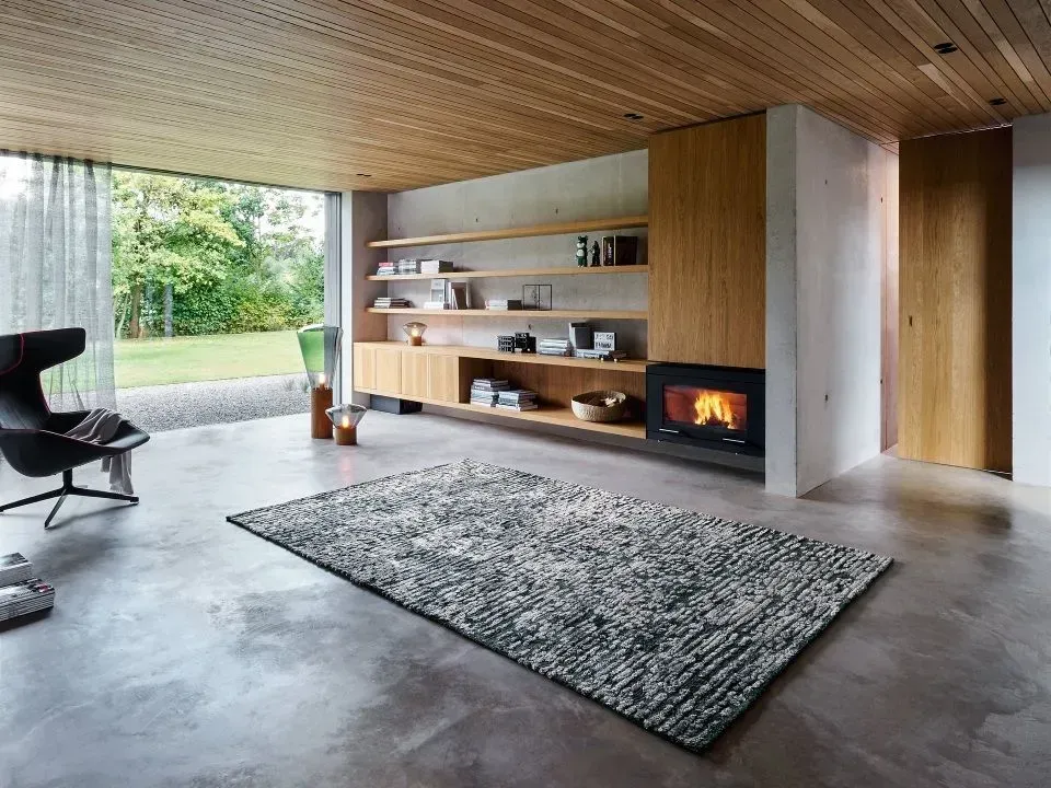 Ein Wohnzimmer mit Teppich und Kamin