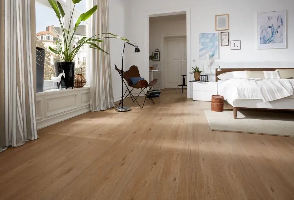 Ein Schlafzimmer mit Bett, Stuhl, Lampe und Fenster