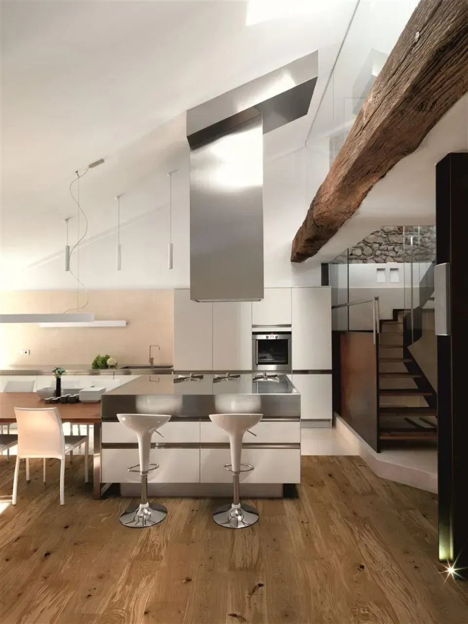 Eine Küche mit weißen Schränken und einer Dunstabzugshaube aus Edelstahl