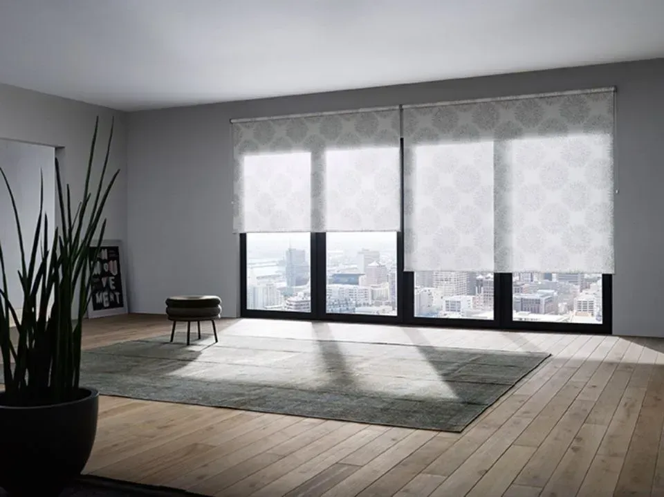 Ein Wohnzimmer mit vielen Fenstern und einem Teppich