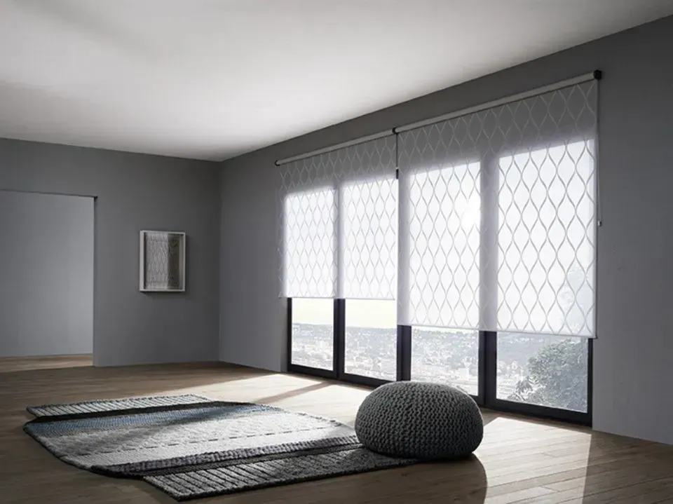 Ein Wohnzimmer mit Teppich, Ottomane und Glasschiebetüren