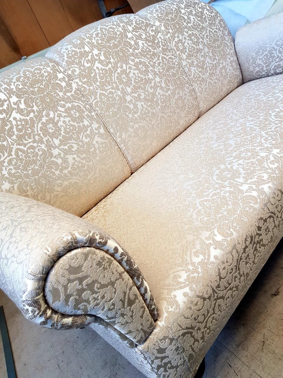 Auf einem Holzboden steht ein weißes Sofa mit Muster