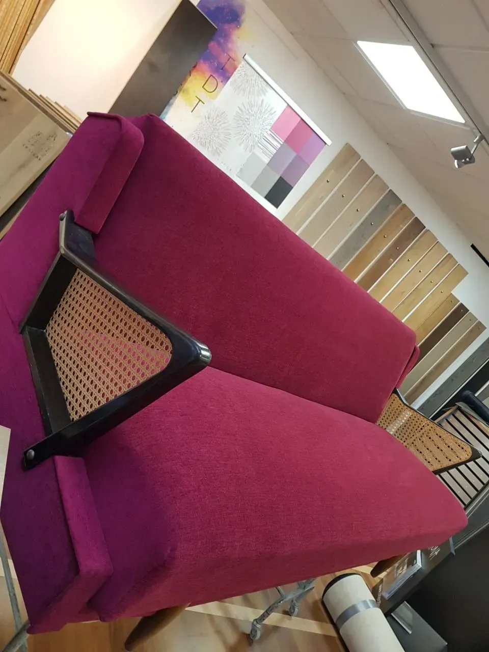 Eine lila Couch mit geflochtenen Armlehnen in einem Zimmer