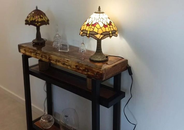 Dos lámparas de vidrieras están sobre una mesa de madera.