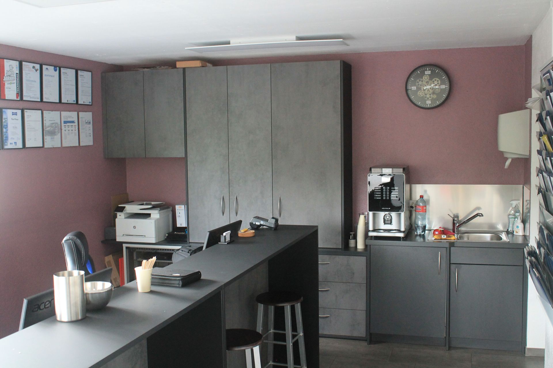 Eine Person hält ein Messgerät vor einen Automotor.